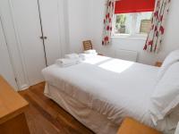 a bedroom with a white bed with towels on it at The Beach House in Newquay