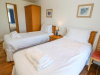 two beds in a hotel room with white sheets at The Beach House in Newquay