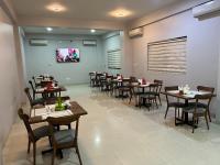 a dining room with tables and chairs in a restaurant at Hotel Golf Coast in Kinshasa