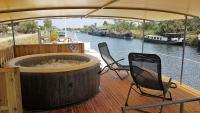 a wooden deck with two chairs and a large tub on a boat at PÉNICHE authentique tout confort in Aigues-Mortes