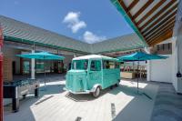 Una camioneta verde estacionada frente a un edificio con paraguas. en Joy Island Maldives All Inclusive Resort, en Male