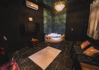 a bathroom with a tub and a tv and a couch at Amour d&#39;une Nuit, LoveRoom in Sarcelles