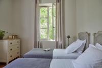 a bedroom with two beds and a window at Château Les Carrasses in Capestang