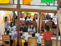 a group of people sitting at tables in a restaurant at Hans Cottage Botel in Cape Coast