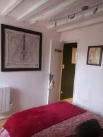 Un dormitorio con una cama con una manta roja. en Au cœur de Mortagne, un balcon sur le Perche, en Mortagne-au-Perche
