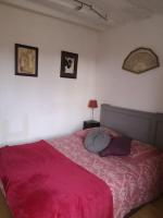 1 dormitorio con 1 cama con edredón rosa en Au cœur de Mortagne, un balcon sur le Perche, en Mortagne-au-Perche