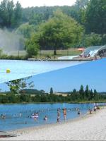 a group of people in the water at a beach at Grand chalet en bois climatisé avec vue sur le lac in Saramon
