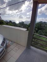 a balcony of a house with a view of the ocean at Les palmiers in Le Marin