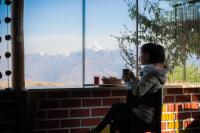 a woman sitting in a chair looking out a window at Sky Dome Peru in Cusco