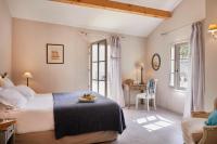 a bedroom with a bed and a desk and window at Château Les Carrasses in Capestang