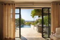 an open glass door to a patio with a pool at Château Les Carrasses in Capestang