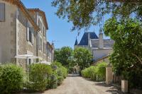 a dirt road between two buildings with an umbrella at Château Les Carrasses in Capestang