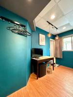 a room with a desk and a blue wall at Taipei Triple Tiger Inn in Taipei