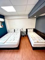 two beds in a room with blue walls and wooden floors at Taipei Triple Tiger Inn in Taipei