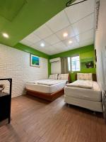 two beds in a room with green walls at Taipei Triple Tiger Inn in Taipei