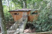a tree house with a staircase leading to it at Les Ecolodges de l&#39;Orbière in Forcé