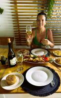 a woman sitting at a table with a glass of wine at Cristal Blue Barú in Baru
