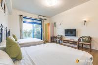 a hotel room with two beds and a television at Promised Land B&amp;B in Taitung City