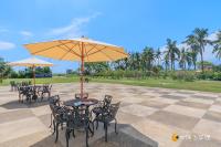 a patio with tables and chairs with an umbrella at Promised Land B&amp;B in Taitung City