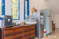 a kitchen with a wooden dresser with a refrigerator at Promised Land B&amp;B in Taitung City