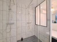 a bathroom with a shower with a glass door at Maputo - Appartement climatisé in Reims