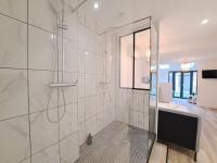 a bathroom with a shower with a glass door at Maputo - Appartement climatisé in Reims