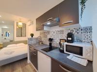 a kitchen with a counter top with a microwave at Maputo - Appartement climatisé in Reims