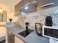 a kitchen with a sink and a microwave at Maputo - Appartement climatisé in Reims