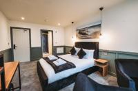 Un dormitorio con una cama, un sofá y una silla. en The Royal Bar &amp; Shaker, en Morecambe