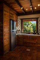 a kitchen with a stainless steel refrigerator and a window at Eco Lodge de Construção Natural com Vista Panorâmica in Nova Friburgo