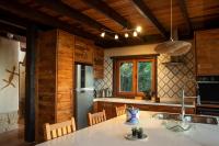 a kitchen with a refrigerator and a table with chairs at Eco Lodge de Construção Natural com Vista Panorâmica in Nova Friburgo