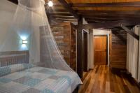 a bedroom with a bed with a mosquito net at Eco Lodge de Construção Natural com Vista Panorâmica in Nova Friburgo