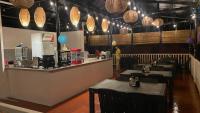 um restaurante com mesas e um bar com luzes em Seaside traveler's Inn by Camiguin Island Home em Catarman