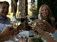 een groep mensen die aan een tafel zitten met wijnglazen bij Vinarosa Resort & Spa in Santa Rosa