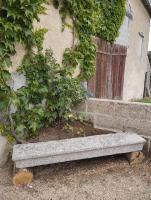 a stone bench sitting in front of a building at Maison au calme avec vue étang in Clessé
