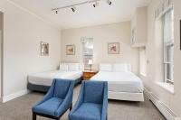 アスペンにあるIndependence Square 213, Spacious Hotel Room with 2 Queen Beds, Wet Bar, and Sitting Areaの青い椅子2脚付きの客室内のベッド2台
