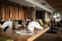 una mesa de madera con platos y servilletas. en Kulmberghaus Resort, en Saalfeld