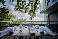 una mesa con copas de vino y servilletas en el balcón en Kulmberghaus Resort, en Saalfeld