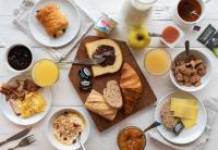 a table topped with plates of breakfast foods and drinks at B&amp;B HOTEL Massieux Genay in Genay