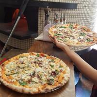 due pizze sedute sopra un tavolo di legno di Apartament Klimt 1 a Bielsko-Biała