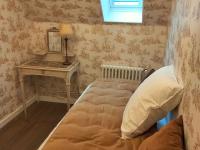 a bedroom with a bed and a table with a mirror at Gîte Bazouges-sur-le-Loir, 6 pièces, 10 personnes - FR-1-410-377 in Bazouges-sur-le-Loir
