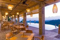 a restaurant with tables and chairs and large windows at Maha Hills Resort by Mahaprana Experience in Lovina