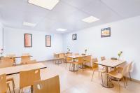 ein Klassenzimmer mit Tischen und Stühlen in einem Raum in der Unterkunft Henghe Selected S-Design Hotel Guangzhou Baiyun Railway Station International Garment City Branch in Guangzhou