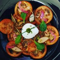 um prato azul com tomates. em Hotel Les Rives Du Doubs em Les Brenets