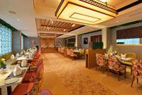 a restaurant with tables and chairs and a chandelier at PARK RESIDENCY ARCADIA in Alwaye