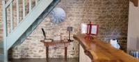 a staircase with a table and a clock on a brick wall at Meublé de tourisme &quot;Les brosses tillots&quot; in Mary