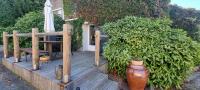 a wooden deck with a chair and an umbrella at Meublé de tourisme &quot;Les brosses tillots&quot; in Mary