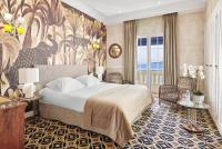 a bedroom with a large bed and a large mural at Hôtel Belles Rives in Juan-les-Pins