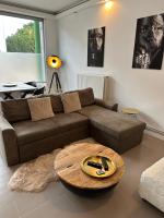 a living room with a brown couch and a table at Antwerp West Side in Zwijndrecht