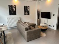 a living room with a couch and a tv at Antwerp West Side in Zwijndrecht